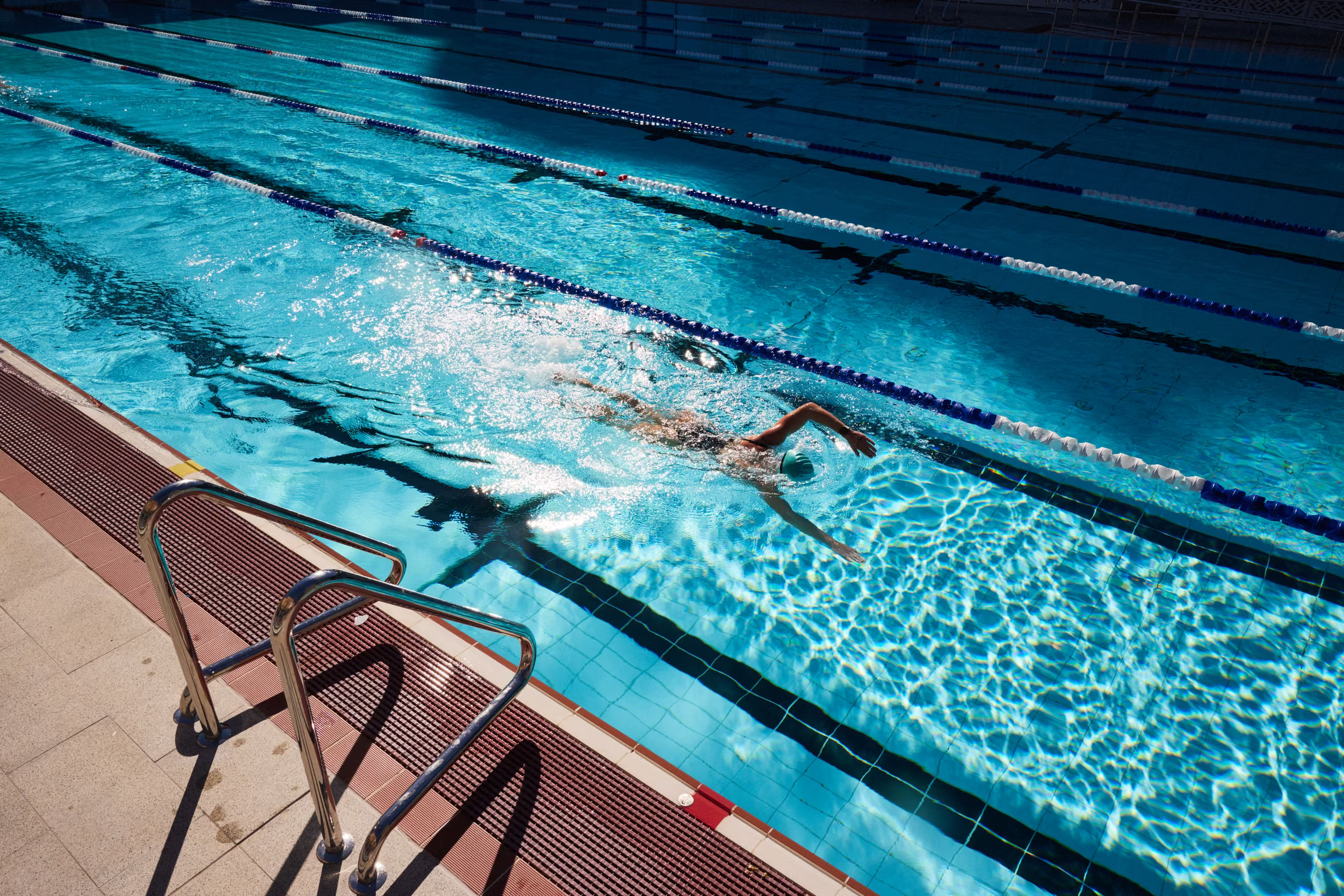 A swimmer working on freestyle technique in the indoor lanes