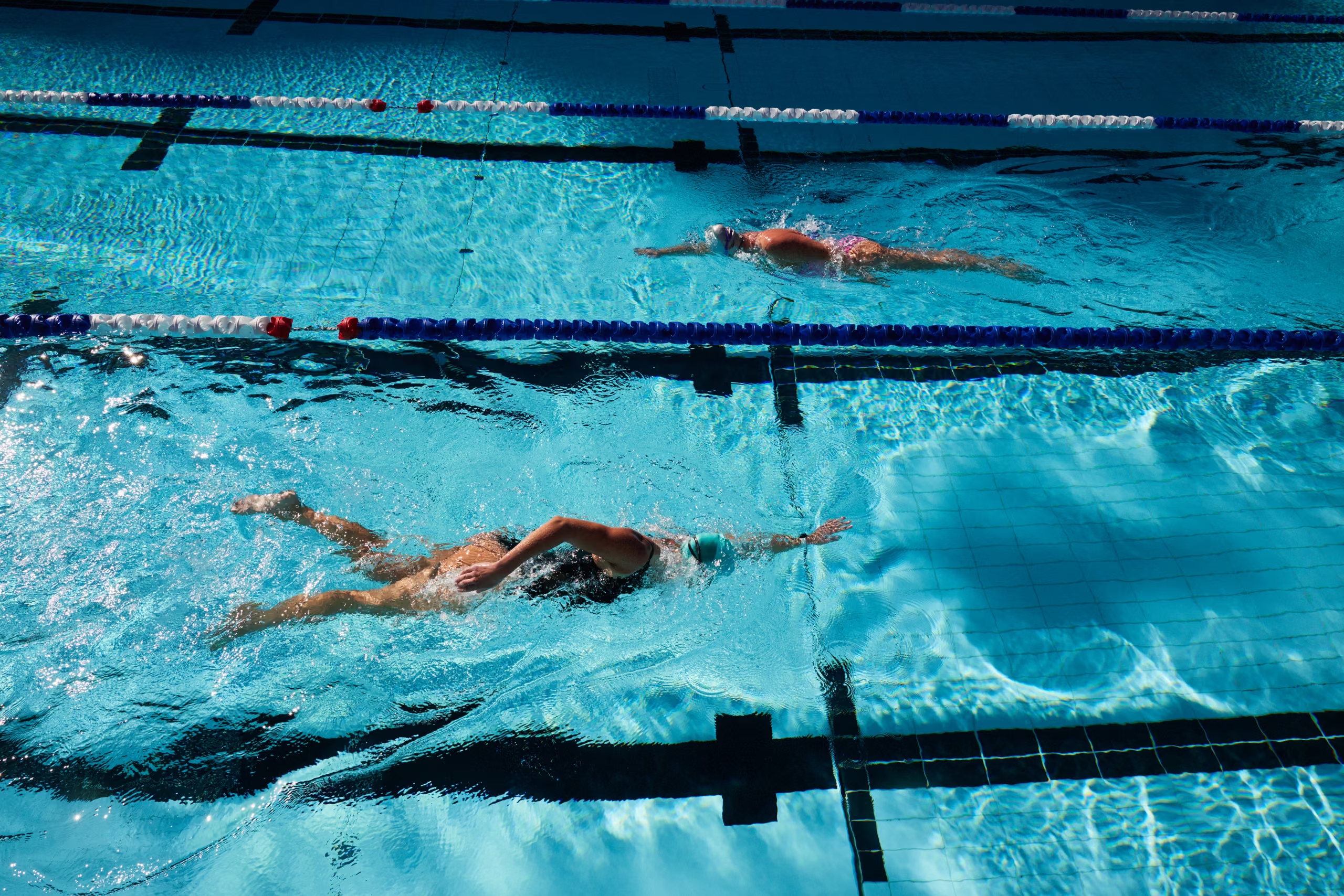 A swimmer doing laps in a marked lane of the indoor pool