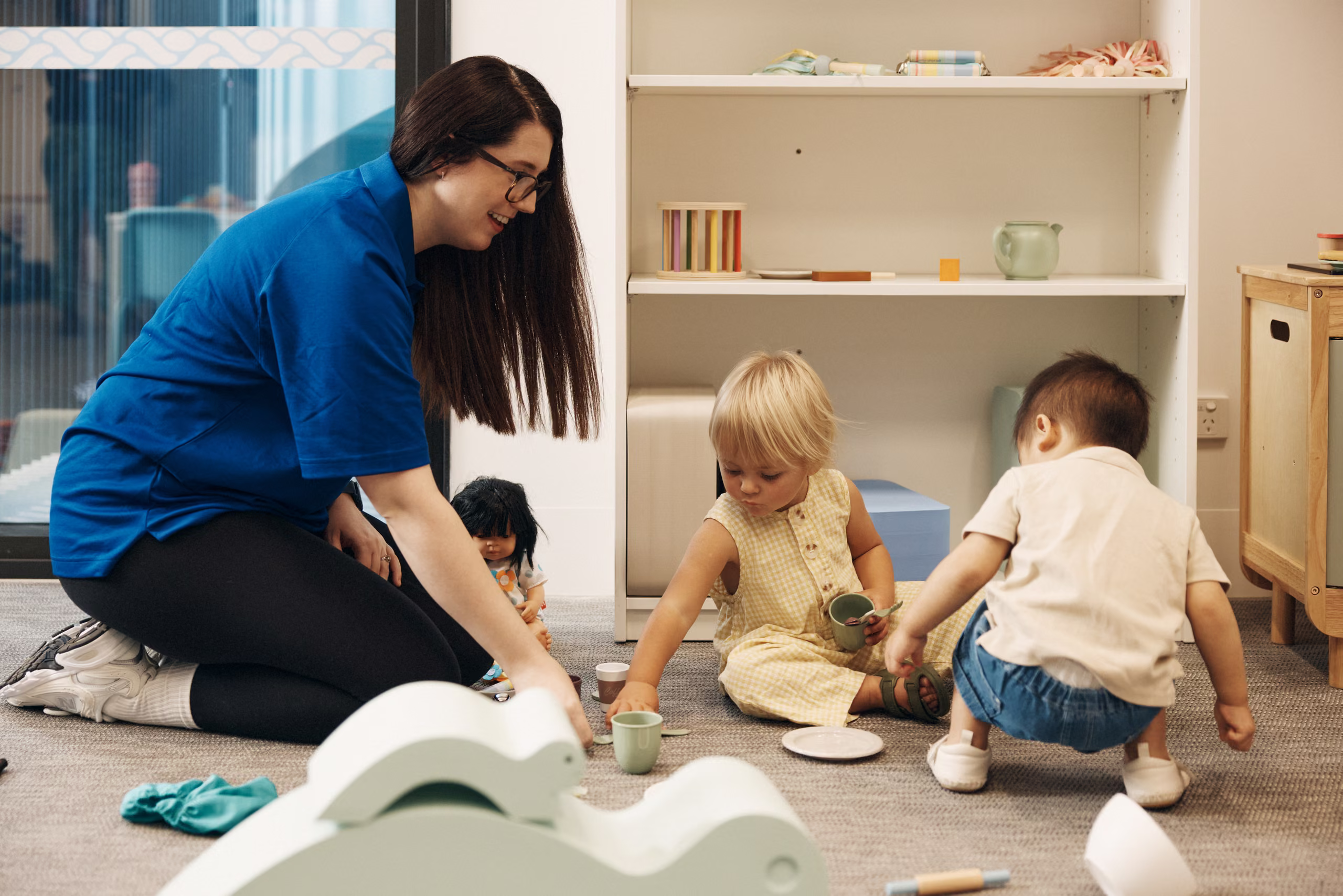 An educator playing with a toddler in the crèche