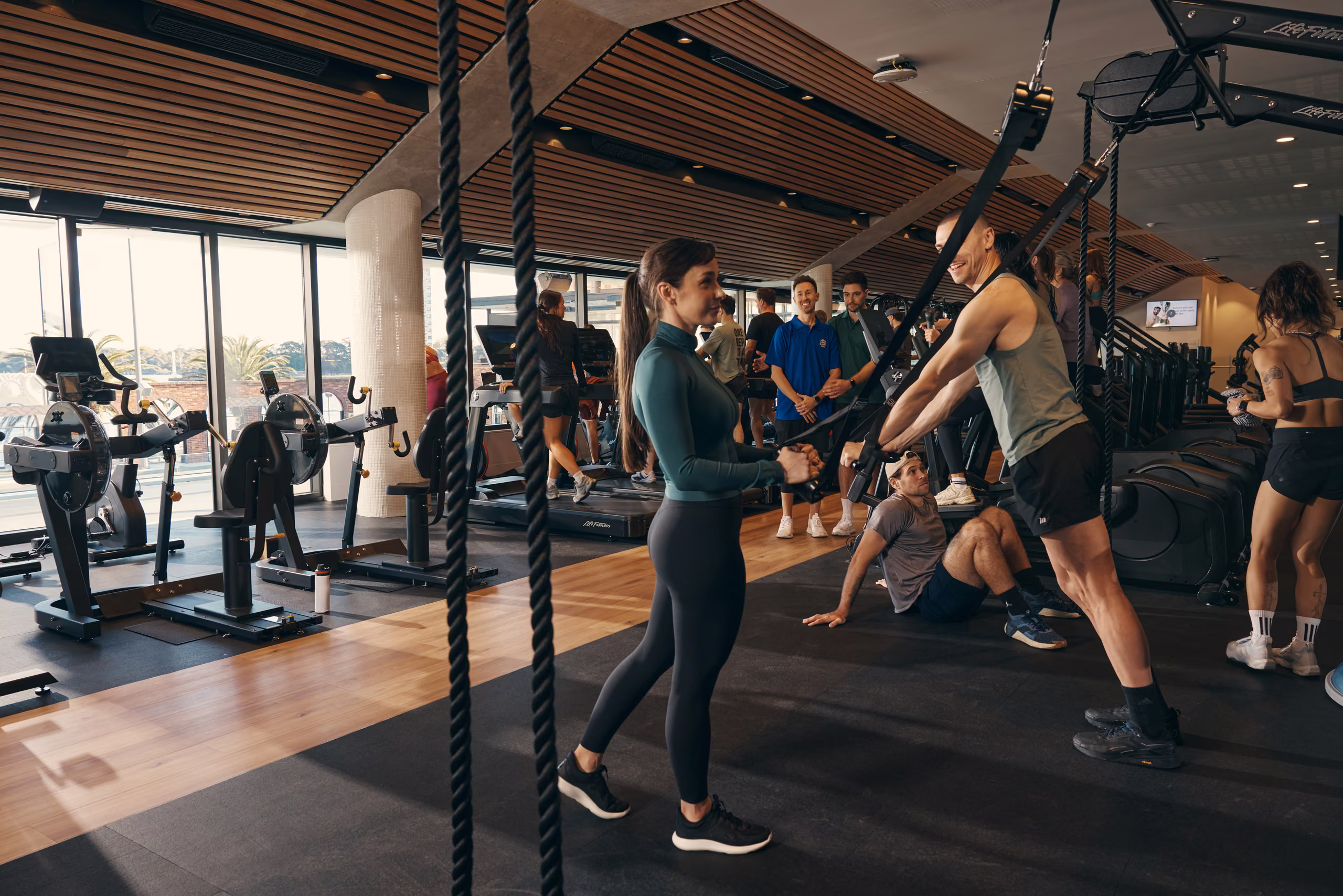 A trainer talking a member through the equipment on the gym floor