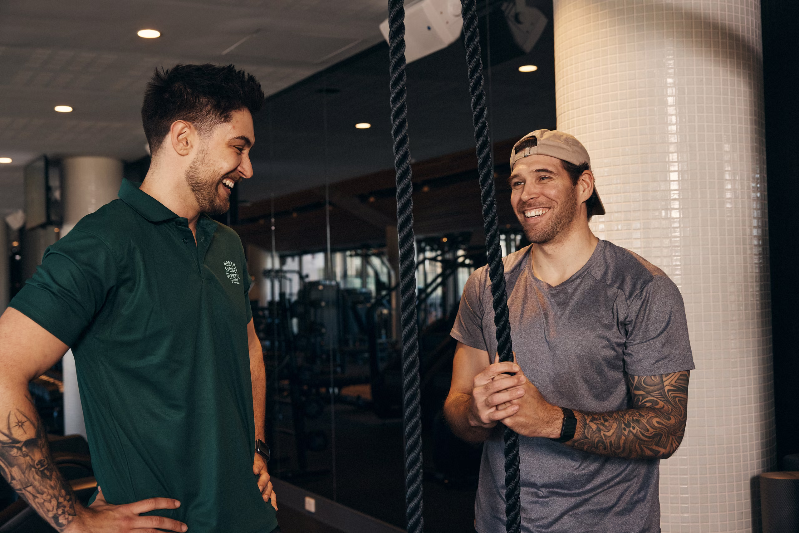 A member and a trainer talking beside the weights