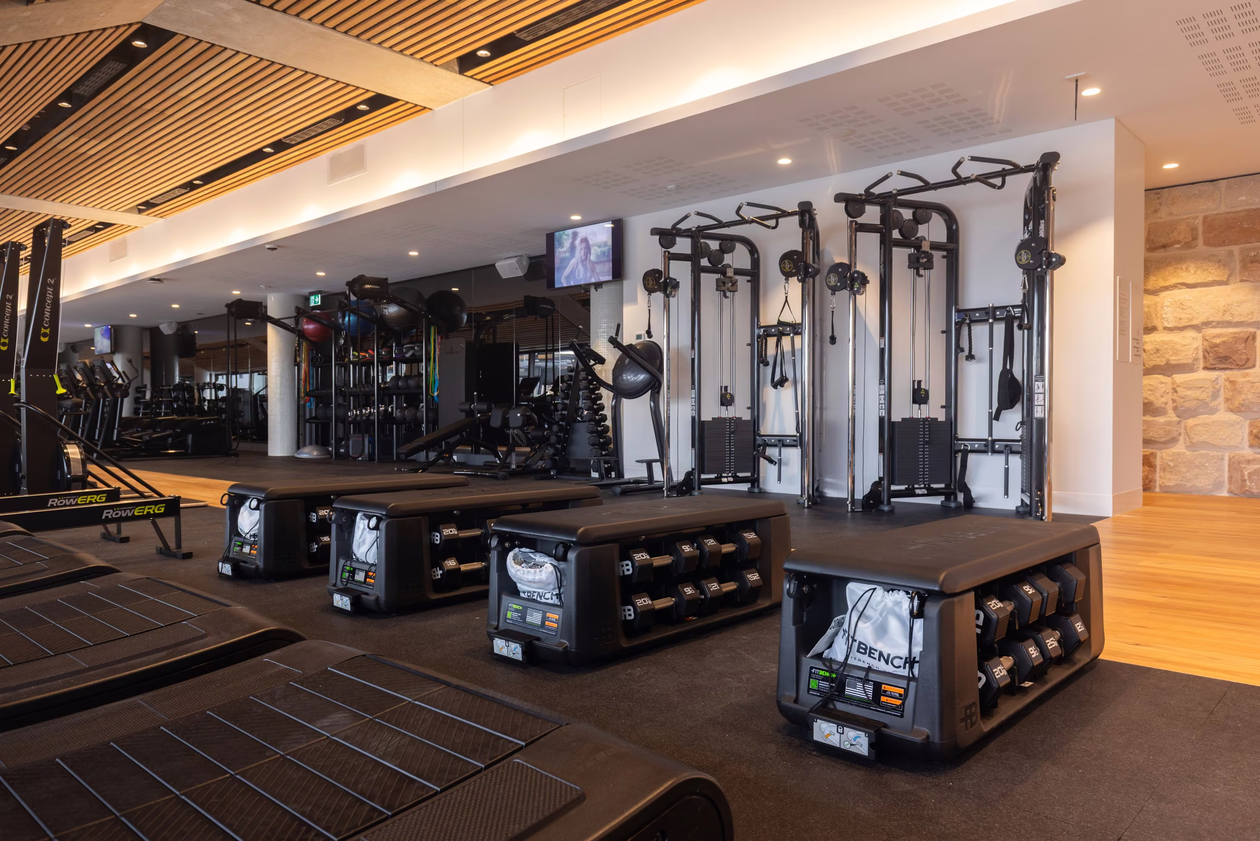 Cable machines and benches in the strength zone beside the sandstone wall