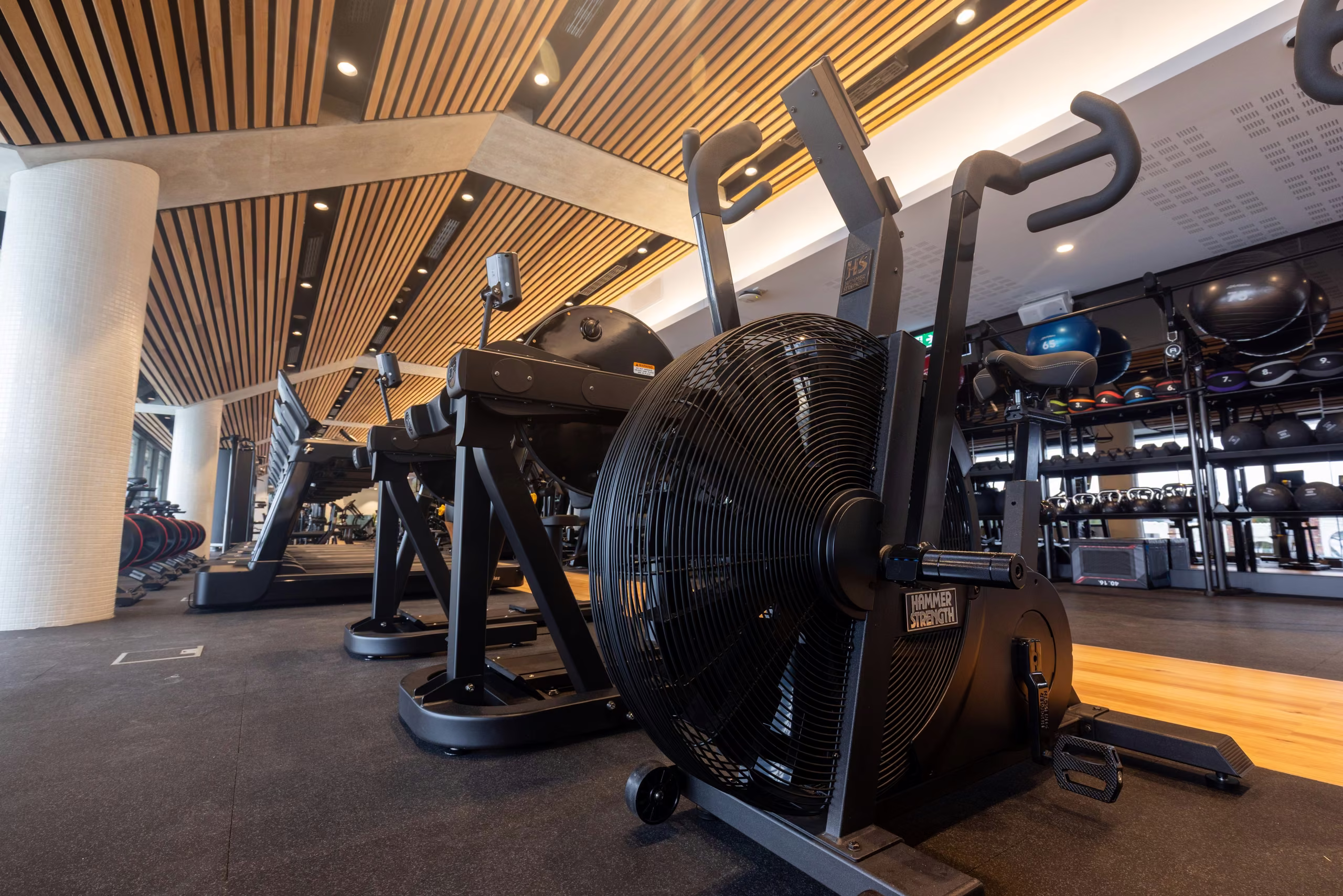 Air bikes and cardio equipment under the timber ceiling